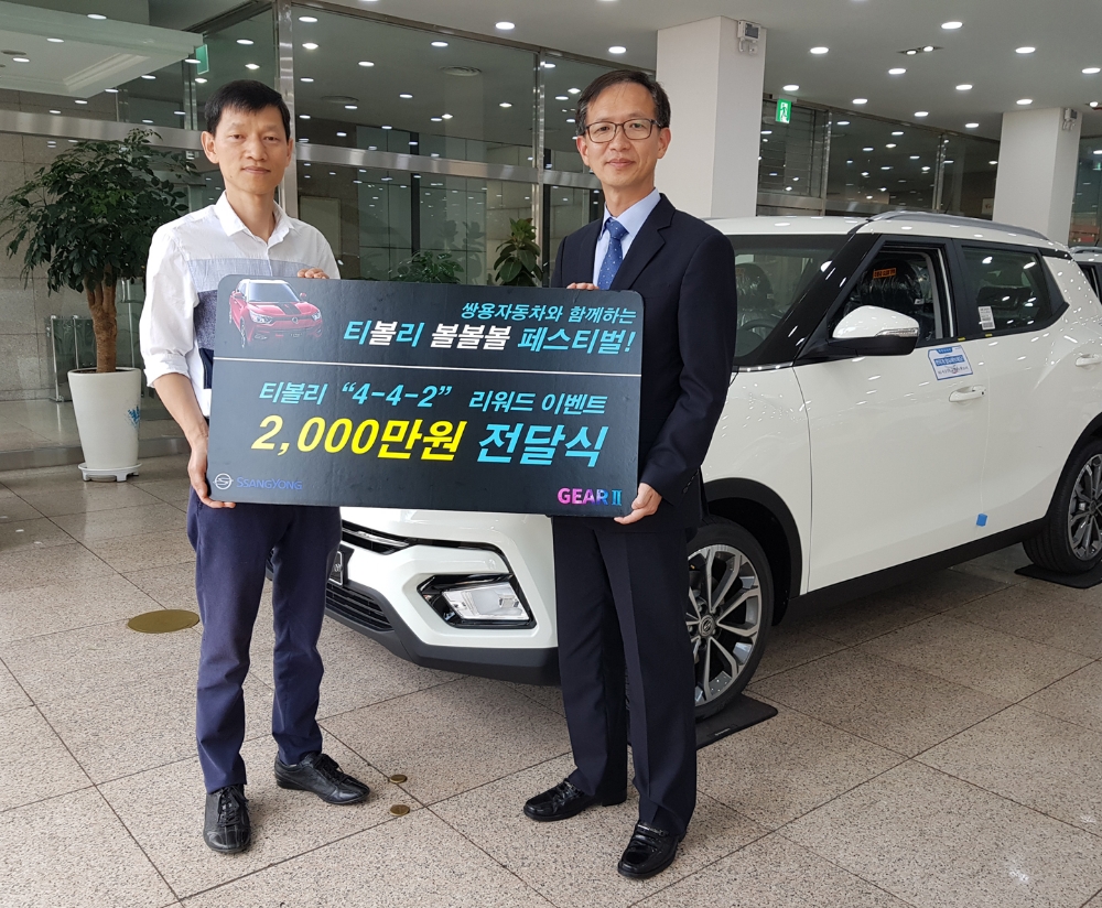 쌍용자동차 박세홍 경인지역본부장(오른쪽)이 2천만원 페이백 행운의 주인공이 된 권영욱씨(52세, 경기 부천)에게 경품을 전달하고 있다.(사진=쌍용자동차)