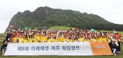 제주 희망캠프에 참가한 지역아동센터 이용 가족들이 제주도 성산일출봉에서 기념촬영을 하고 있다. (사진=미래에셋대우)