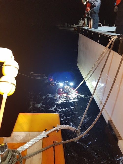 해경 잠수요원 2명이 추진기에 씨앵카 줄이 감긴 것을 확인하고 이를 제거하고 있다.(사진제공=부산해양경찰서)