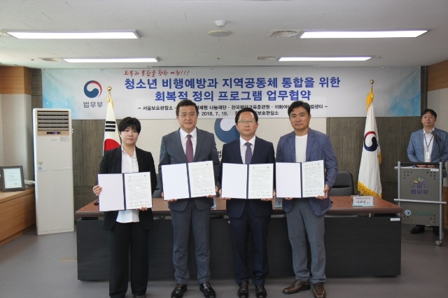 업무협약서를 내보이며 기념촬영을 하고 있다.(사진제공=서울준법지원센터)