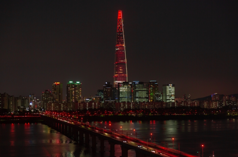 롯데는 21일 롯데월드타워에서 스포츠와 문화예술을 통해 발달장애인이 포용받는 사회를 만들어가자는 취지의 스페셜올림픽 50주년 기념 점등식 ‘Light Up For Inclusion’을 개최했다. 사진은 붉은 빛이 점등된 롯데월드타워의 모습. (사진=롯데)