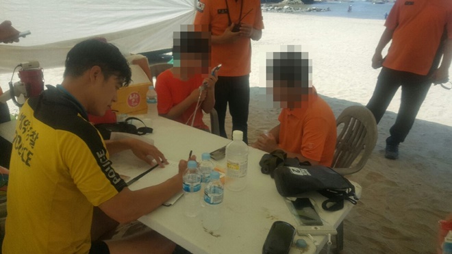 익수자를 구조해 보호자에게 인계하고 있다.(사진제공=부산해경)