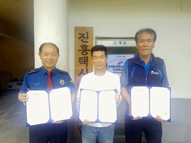 울산남부경찰서 신정지구대와 진흥택시-노조가 업무협약서를 내보이며 기념촬영을 하고 있다.(사진제공=울산남부경찰서)