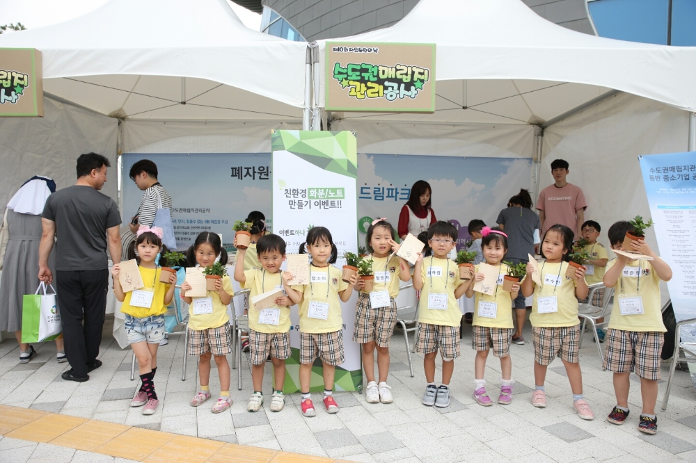 SL공사 부스를 방문한 관람객들이 바이오가스로 키운 허브화분을 받고 친환경 노트 만들기 체험을 하고 있다.(사진=SL공사)