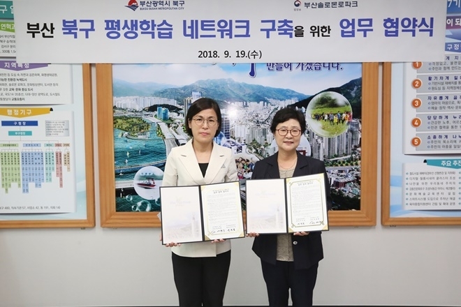 (사진왼쪽부터) 정명희 부산 북구청장과 서진남 센터장이 업무협약서를 내보이며 기념촬영.(사진제공=부산솔로몬로파크)