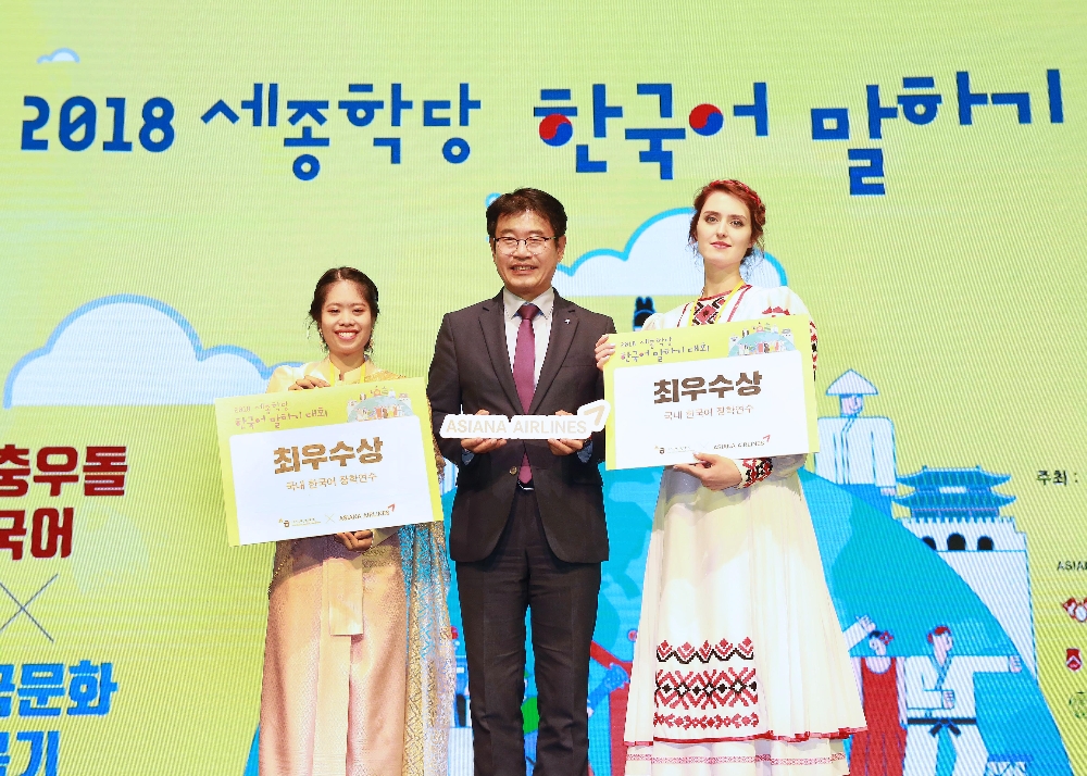 지난 4일, 서울시 코엑스 아티움에서 개최된 '2018 세종학당 한국어 말하기 대회'에서 아시아나항공 조영석 상무(가운데)가 최우수상인 '아시아나항공상'의 수상자 쁘라까이묵씨(왼쪽, 태국), 몰찬 야나씨(오른쪽, 벨라루스)와 함께 기념촬영을 하고 있다. (사진=아시아나항공)