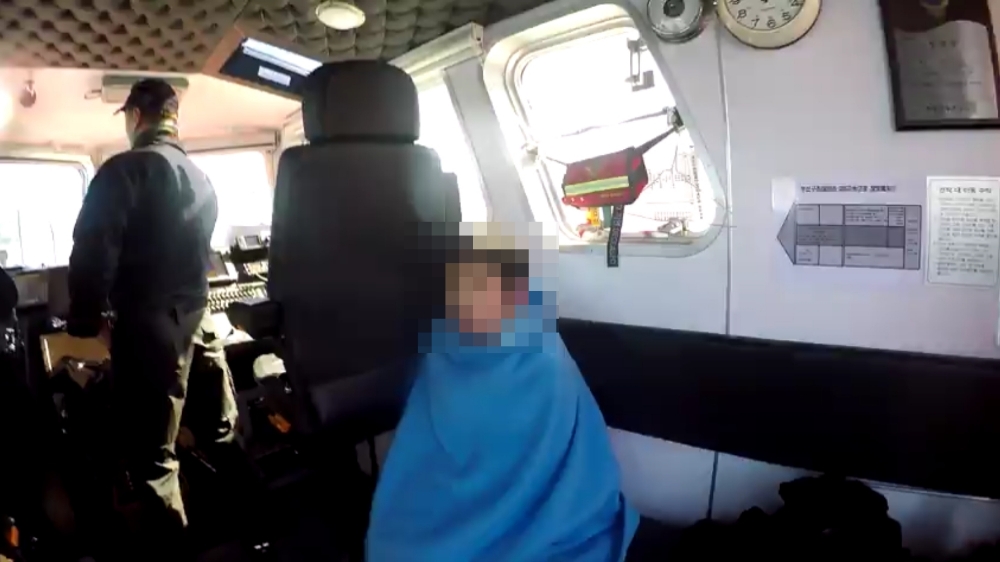 초등학생을 구조해 담요로 체온을 높이고 있다.(사진제공=부산해양경찰서)