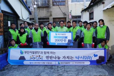 보드 정중앙 강정칠 부산연탄은행 대표, 중앙좌측 최광식 노조위원장, 중앙좌좌측 이정희 관리본부장, 중앙우측 추연길 이사장, 중앙우우측 조규호 경영본부장이 기념촬영을 하고 있다