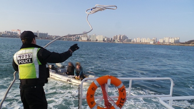 방어진해경파출소 해양경찰관이 표류보트로 예인줄을 넘겨주고 있다,(사진제공=울산해양경찰서)