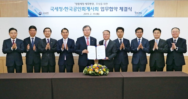 업무협약서를 내보이며 기념촬영.(사진제공=국세청)