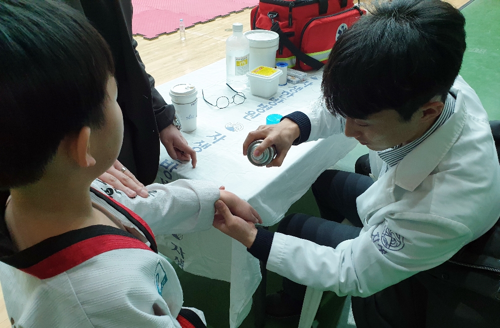 사진=분당자생한방병원 의료진이 태권도 경기 중 부상당한 선수를 치료하고 있다.