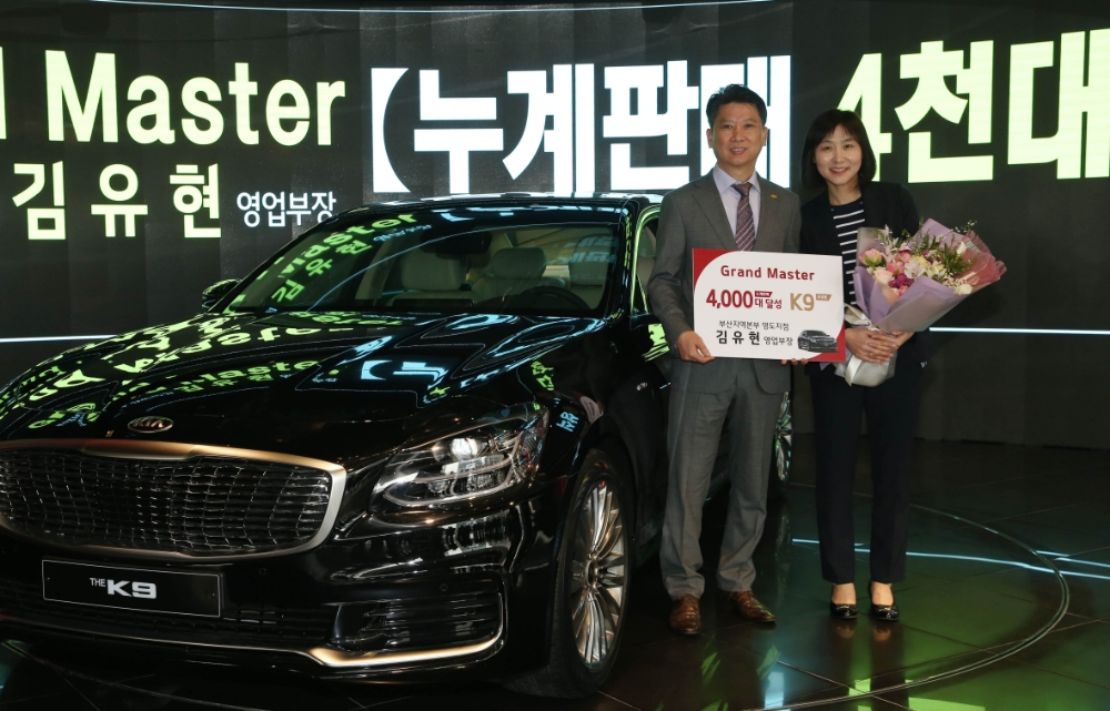 누계판매 4천대를 달성한 ‘그랜드 마스터’ 김유현 영업부장(부산 영도지점)이 아내와 기념촬영을 하고 있다.(사진=기아자동차)