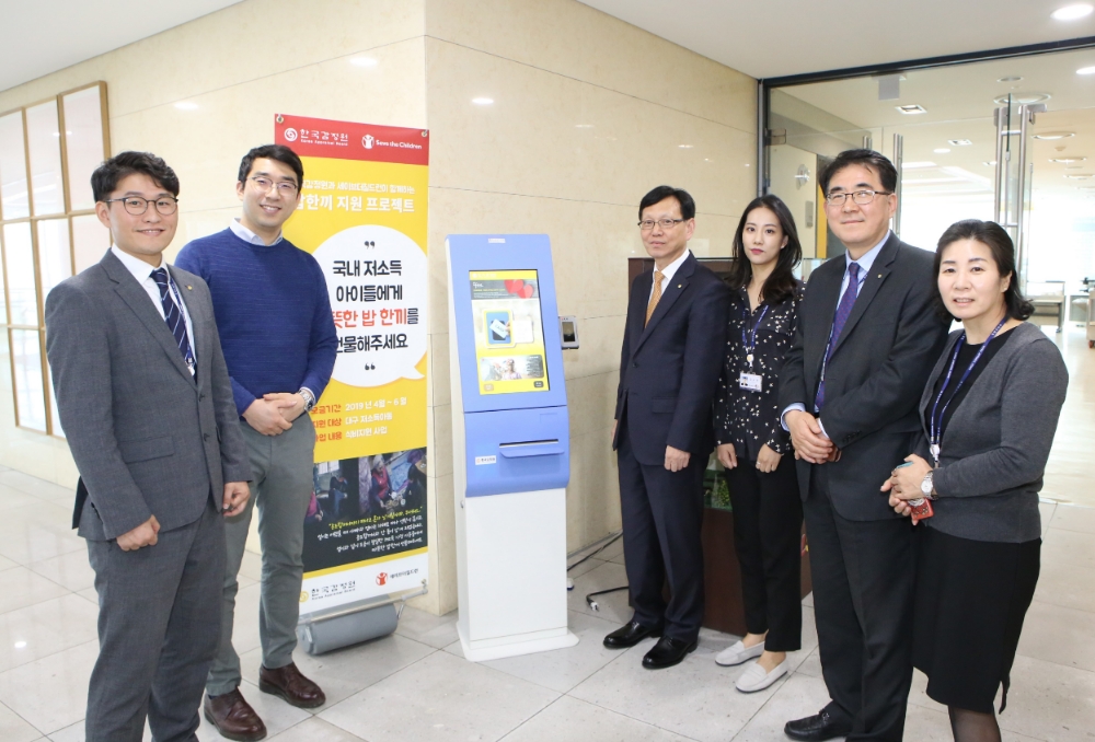 한국감정원 본사 구내식당 내 식권발매기(KIOSK) 앞에서 한국감정원 정건용 부원장(오른쪽 네번째)과 직원들이 기부하고 있다.(사진=한국감정원)
