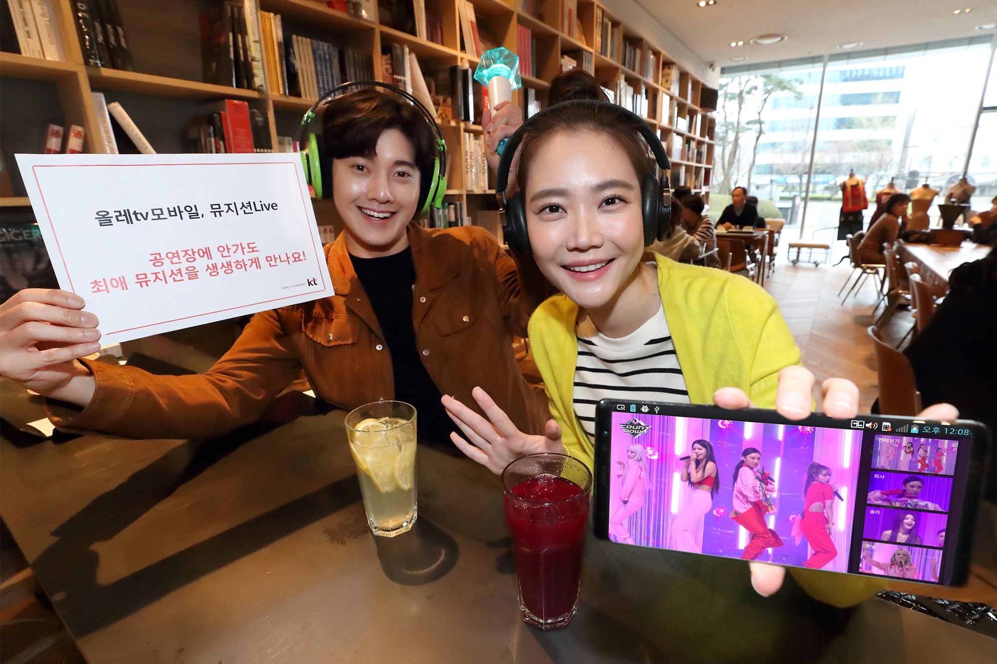 KT 모델들이 올레 tv 모바일에서 제공하는 ‘뮤지션 Live’ 서비스를 소개하고 있다. 사진=KT