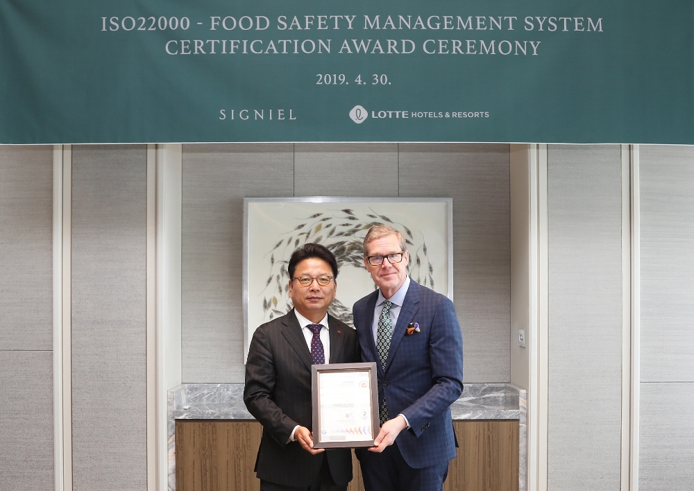 지난달 30일 시그니엘서울 76층 연회장에서 열린 ISO22000 인증서 수여식에서 롯데호텔 김정환 대표이사(좌측)와 리누스 폰 카스텔무르 주한 스위스 대사(우측)가 기념촬영을 하고 있다.(사진=롯데호텔)