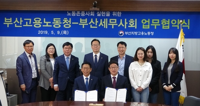 강정순 부산지방세무사회장(앞줄 왼쪽)과 최기동 부산고용노동청장이 업무협약서를 내보이며 기념촬영.(사진제공=부산고용노동청)