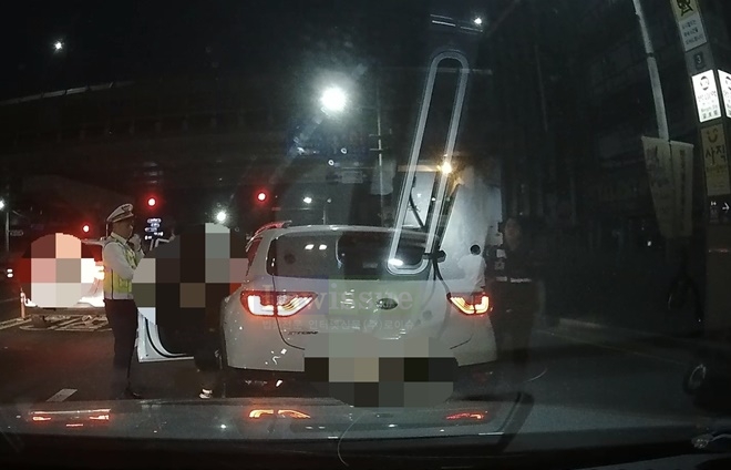 타이어펑크난 상태로 도주한 음주운전자를 검거하고 있다.(사진제공=부산경찰청)