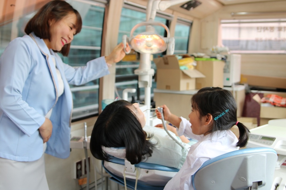 김천희 수원인계 유디치과의원 치위생사가 아이들에게 치과의사 직업체험을 진행하고 있는 모습. (사진=유디치과)