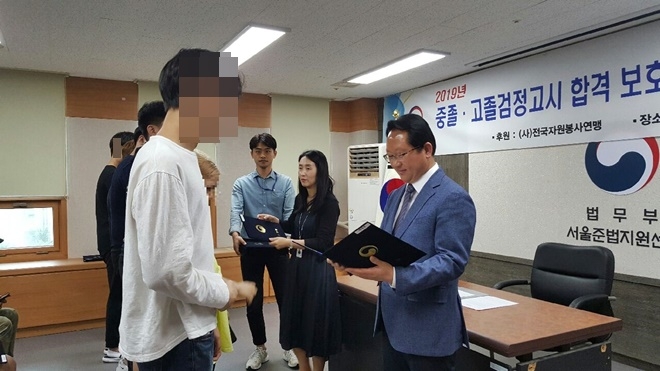 검정고시 합격한 보호관찰청소년들에게 장학증서를 전달하고 있다.(사진제공=서울준법지원센터)