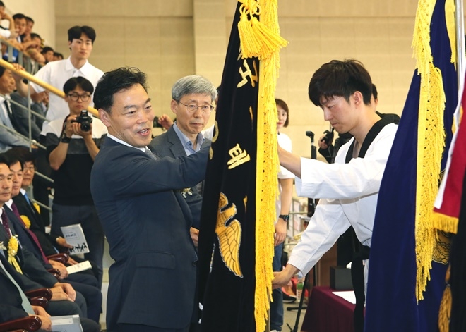 김오수 차관이 지난해 태권도 우승팀으로부터 우승기를 전달받고 있다.(사진제공=법무부)