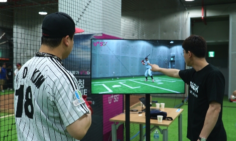 지난 6월 9일 ‘U+5G 사회인 야구대회’의 본선행사로 진행된 원포인트 레슨에서 참가자가 코치와 함께 본인의 타격폼을 여러 각도에서 돌려보며 교정받고 있는 모습. 사진=LG유플러스
