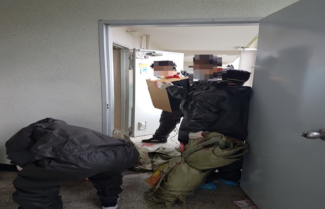 사회봉사대상자들이 저장강박 가구의 집안음식물, 생활쓰레기 등을 치우고 있다.(사진제고=부산서부준법지원센터)