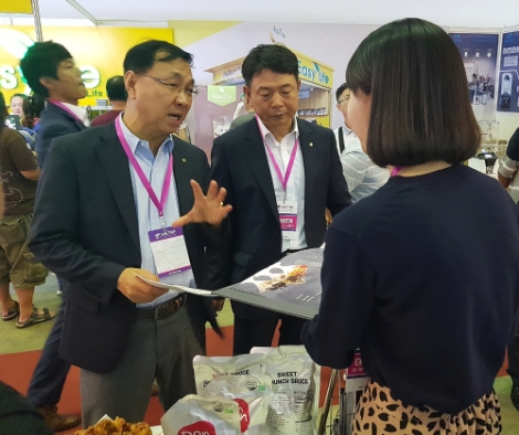 호치민 프랜차이즈 박람회 한국관 참가기업 부스를 둘러보고 있는 신현곤 식품수출이사. 사진=aT