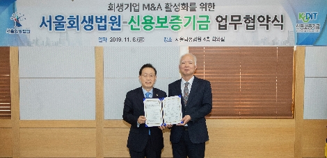 윤대희 신용보증기금 이사장(왼쪽)이 정형식 서울회생법원장(오른쪽)과 함께 8일 서울회생법원에서 열린 '회생기업 M&A 활성화를 위한 업무협약'에서 기념촬영을 하고 있다. 사진=신용보증기금