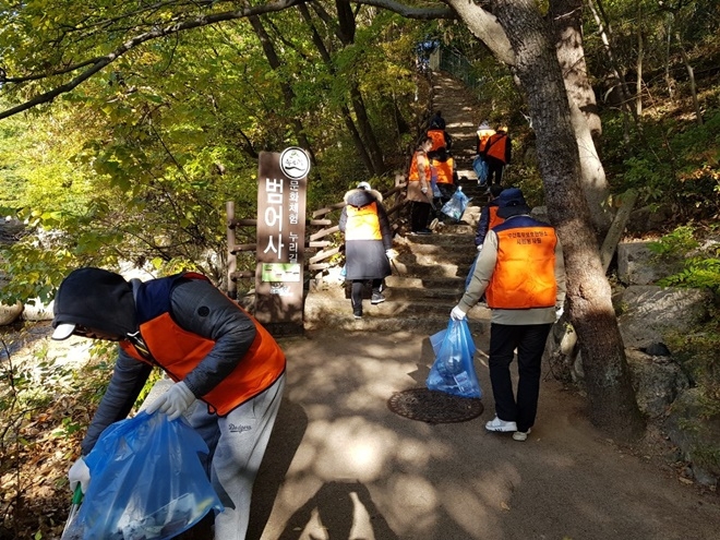 사회봉사대상자들이 범어사 누리길 환경정화 활동을 벌이고 있다.(사진제공=부산동부준법지원센터)