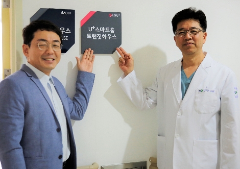 U+스마트홈 서비스가 구축된 양산부산대학교병원 재활병동의 트랜짓하우스에서 (왼쪽부터)LG유플러스 이규화 CSR팀장과 양산부산대학교병원 신용일 재활병원장이 기념촬영을 진행하는 모습. 사진=LG유플러스