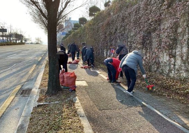 사회봉사대상자들이 인도를 청소하고 있다.(사진제공=전주준법지원센터)