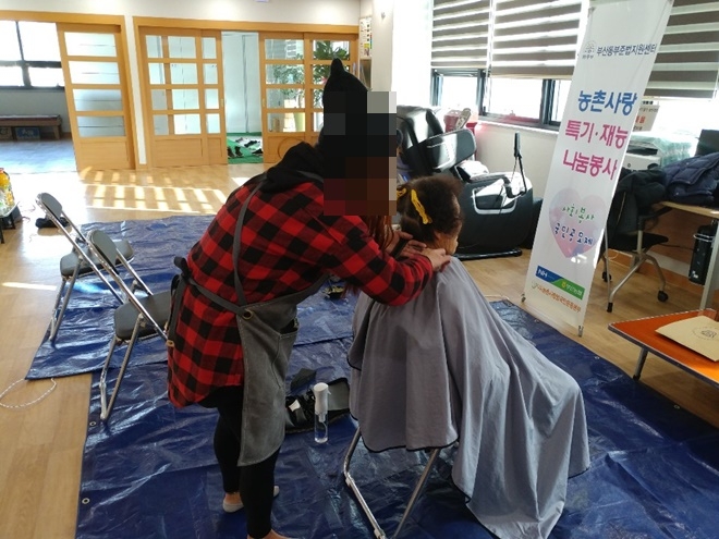 미용특기를 가진 사회봉사대상자가 어르신 머리를 손질하고 있다.(사진제공=부산동부준법지원센터)