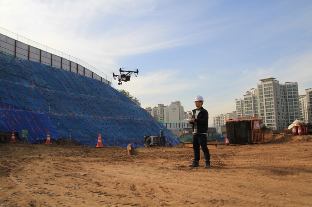 롯데건설 기술연구원 관계자가 건설 현장에서 드론으로 현장을 촬영 중이다.(사진=롯데건설)