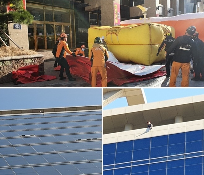 18층 옥상난간에서 투신 소동을 벌이고 있는 한국노총 조합원.(사진제공=부산경찰청)