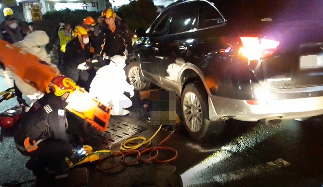 부산항만소방서 구조대원이 차량밑에 역과된 피해자를 구조하고 있다.(사진제공=부산소방본부)