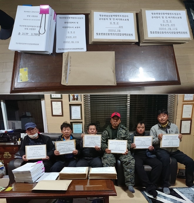 대책위관계자들이 청송군청을 비롯한 관계관청에 보내는 풍력발전단지사업의 반대명부와 성명서를 들어 보이고 있다.