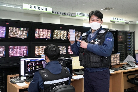 ADT캡스보안요원이 ‘캡스 스마트빌리지’ 앱을 구동하고 있는 모습. 사진=SK텔레콤