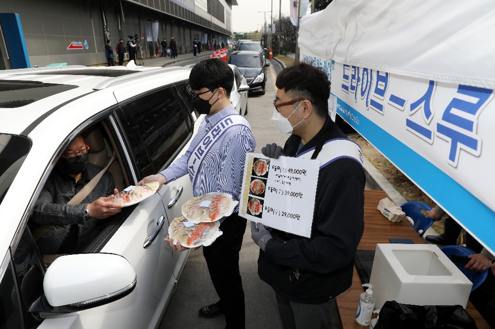서울 동작구 노량진수산시장에 설치된 드라이브 스루 판매 부스에서 직원이 차 안의 고객에게 모둠회를 건네고 있다.(사진=수협중앙회)