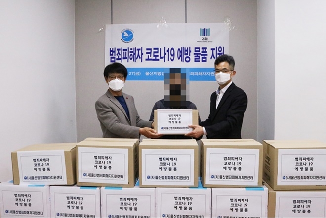 울산범죄피해자지원센터 김복광 이사장(왼쪽)과 울산지방검찰청 김원학 인권감독관(오른쪽)이 3월 27일 ‘범죄피해자 코로나 19 예방 물품 지원’ 행사에 참석해 코로나19 예방 물품을 피해자에게 전달하고 있다.(사진제공=울산범죄피해자지원센터)