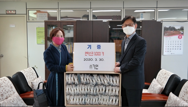 ㈜가연 정가연 대표가 권기한 원장에게 면마스크 1000매를 기증하고 기념촬영.(사진제공=오륜정보산업학교)