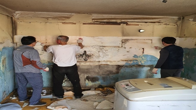 사회봉사대상자들이 독거노인세대에 도배 작업을 하고 있다.(사진제공=통영준법지원센터)