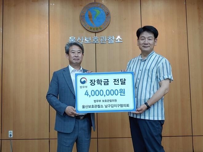 신용일 남구갑협의회장이 장학금을 권을식 소장(우측)에게 전달하고 기념촬영.(사진제공=울산준법지원센터)