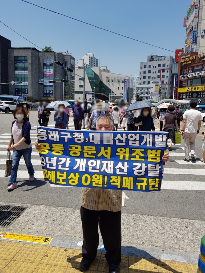 지난 9년간 재판으로 심신이 상처를 받았다는 박모 씨가 동래역 근처에서 1인 시위를 벌이고 있다.