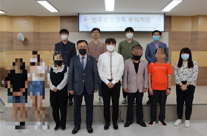 정봉영 지부장(앞줄 사진왼쪽네번째), 김은성 대표(우측 네번째) 등이 법무보호대상자 및 가족 초청 물품 전달식을 갖고 기념촬영.(사진제공=한국법무보호복지공단 경남지부)