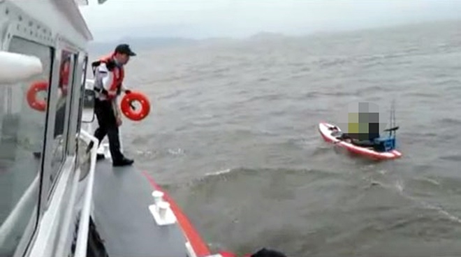 패들보드 표류 레저객을 구조하고 있다.(사진제공=부산해양경찰서)