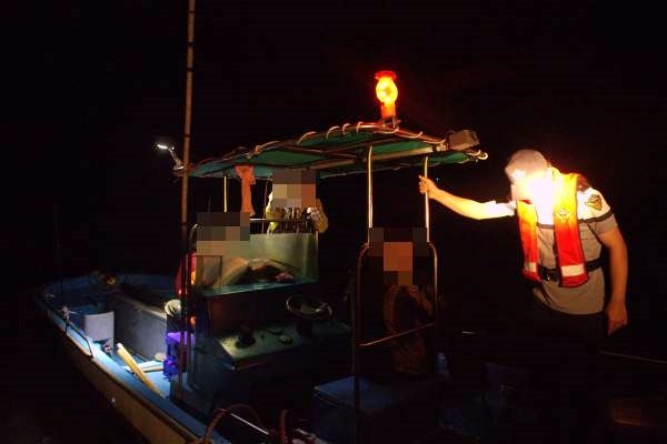 해경이 번호판 미부착하고 무면허로 동력수상레저기구를 운항한 모터보트를 단속 하고 있다.(사진제공=부산해양경찰서)