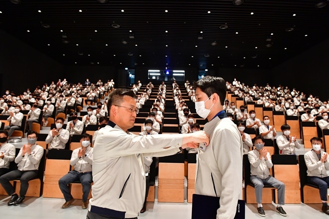 (왼쪽)울산공장 부공장장인 최준혁 전무가 신입사원 대표 노대혁 사원에게 사원증을 수여하고 있다.(사진제공=현대자동차)