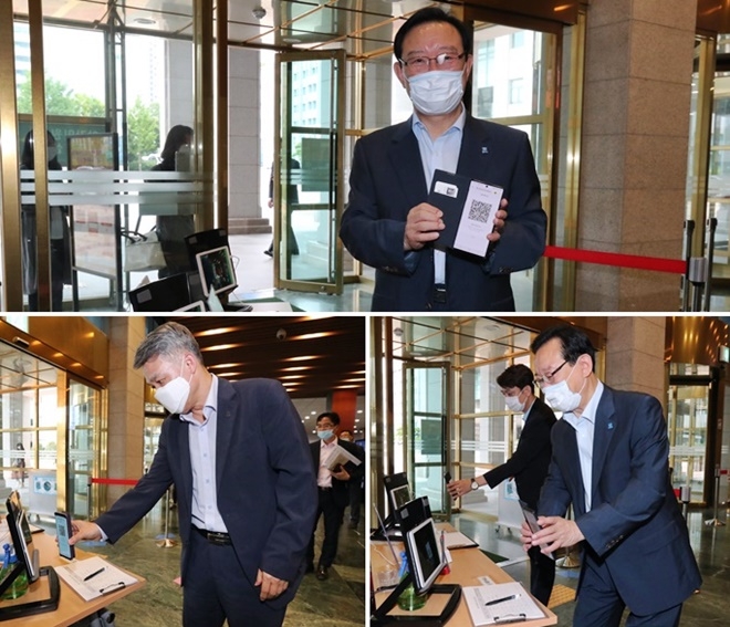 울산시가 27일부터 시 청사에 QR코드를 활용한 전자출입명부 시스템을 도입한 가운데 송철호 시장과 김석진 행정부시장이 스마트폰으로 태블릿 PC화면에 QR코드 출근 스캔을 하고 있다.(사진제공=울산시)