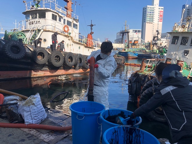 지난 2월 부산 대평동 물량장 앞 해상에서 장기계류 중 침몰한 선박에서 기름이 유출돼 해양경찰이 유회수기를 투입해 회수하고 있다.(사진제공=남해해경청)