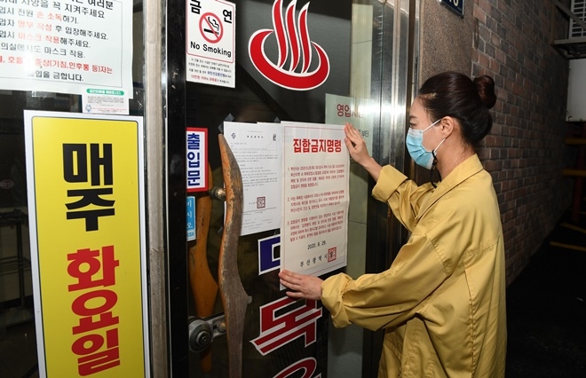 28일 밤 7시 50분 경 기장군청 직원이 부산시 집합금지 행정명령으로 29일 0시부터 영업 중단되는 기장군 관내 목욕장에 집합금지 행정명령 안내문을 부착하고 있다. 기장군은 부산시 집합금지 행정명령으로 29일 0시부터 9월 6일까지 영업 중단되는 관내 목욕장 24곳에 대해 각 사업장당 긴급 재난지원금 100만원을 9월 1일부터 지급할 수 있도록 검토 중이다. (사진제공=부산기장군)